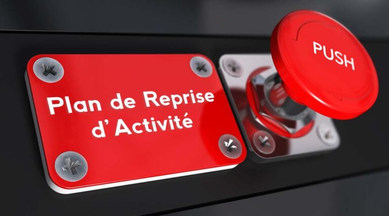 Gros plan d'un bouton d'urgence rouge portant la mention PUSH à côté d'une plaque rouge portant la mention Plan de Reprise d'Activité, soulignant l'importance de concevoir un plan de reprise d'activité informatique pour une continuité efficace de l'activité.
